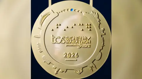Huy chương Sydney Marathon có hình ảnh giống sân Allianz Arena của Munich