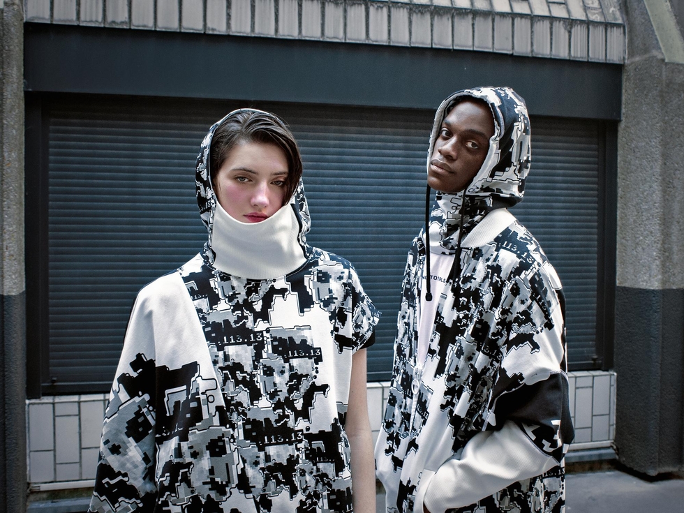 Hai người trẻ mặc áo hoodie với họa tiết đen trắng trừu tượng